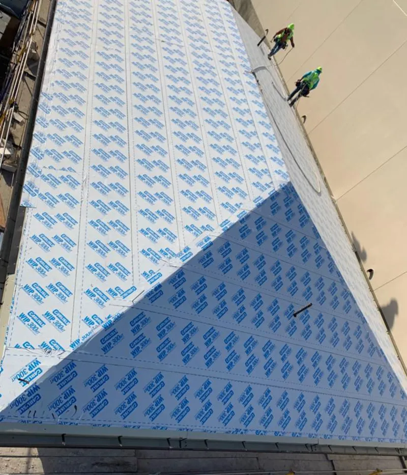 Professional roofers installing underlayment on a metal roof in St. John